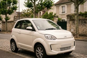 Ligier Myli voiture sans permis blanche garée dans une rue résidentielle française vue de trois quarts avant